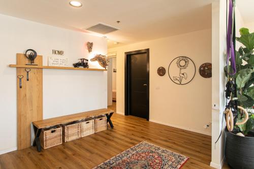 a living room with a wooden floor and a black door at Tirat Carmel Penthouse in Tirat Karmel