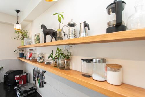 a kitchen with wooden shelves with pots and pans at Tirat Carmel Penthouse in Tirat Karmel