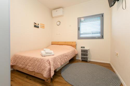 a small bedroom with a bed and a window at Tirat Carmel Penthouse in Tirat Karmel