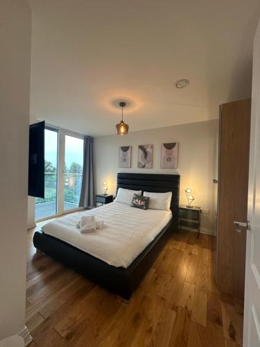 a bedroom with a large bed and a television at Lovely flat in Kingston Town in Kingston upon Thames