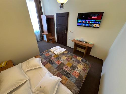 a bedroom with a bed and a tv on the wall at Casa Maria Arges in Piteşti