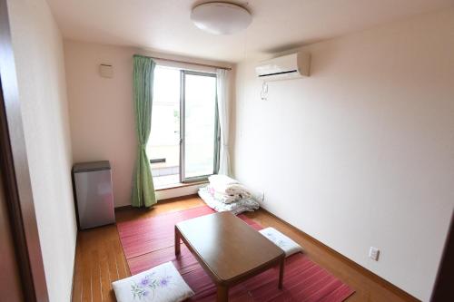 a living room with a table and a window at ファミリー不向き!!素泊まり一棟貸切りではない個室の静かな方限定無料WiFi in Irumagawa