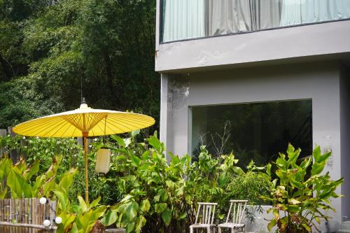 a yellow umbrella sitting in front of a house at CANG 藏In山院 in Yangshuo