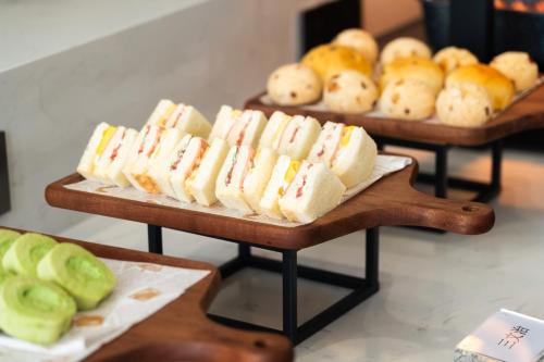 a bunch of sandwiches and rolls on trays with apples at Poltton Century Hotel Yangjiang Jinshan Road in Dongcheng