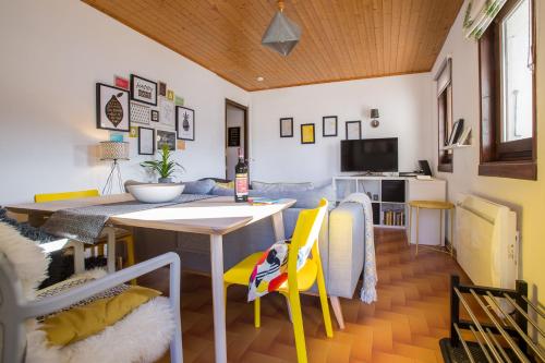 un salon avec une table et des chaises jaunes dans l'établissement Mountainside Apartment with views over Morzine, à Morzine