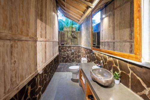a bathroom with a sink and a toilet at Meraki Luxury Villa in Pemuteran