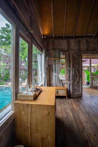 a kitchen with a wooden counter and windows in a room at Meraki Luxury Villa in Pemuteran