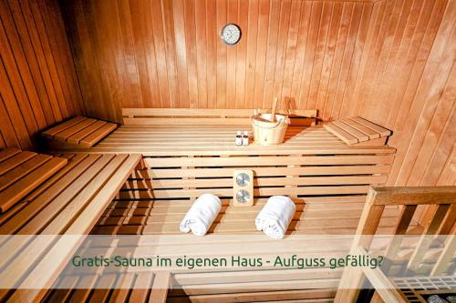 a wooden sauna with a clock on the wall at Luxus-Villa mit Indoorpool, Sauna & offenem Kamin in Siegsdorf