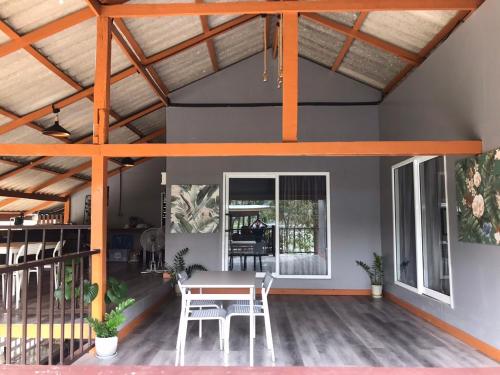 una habitación con mesa y sillas en una casa en 66 Baanaisuan 66 บ้านในสวน, en Ban Komo Sam Sip Paet