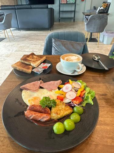 南芭堤雅Friends Station Tukkom Hostel & Cafe的餐桌,早餐盘和咖啡