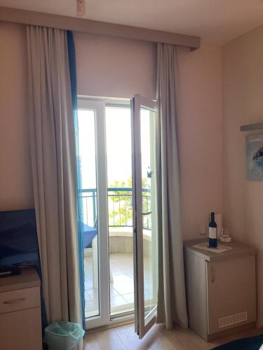 a room with a sliding glass door with a balcony at Apartments Villa Loznica in Brela