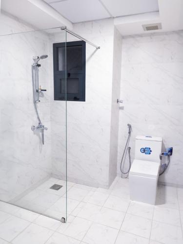a bathroom with a glass shower with a toilet at Liza Hotel in Muscat