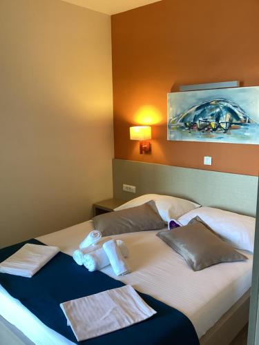 a hotel room with a bed with towels on it at Apartments Villa Loznica in Brela