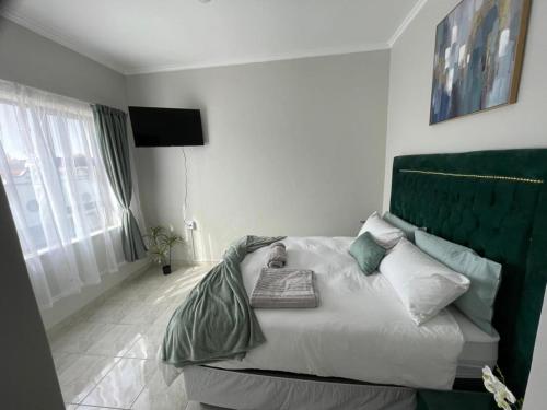 a bedroom with a bed with a green headboard at The View Apartment 2 in Lüderitz