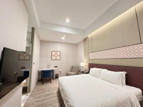 a hotel room with a bed and a desk at 台南星鑽國際商旅 Hua Hotel in Tainan