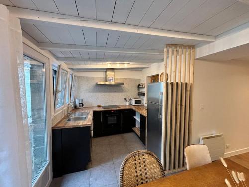 La cuisine est équipée d'un réfrigérateur et d'un évier. dans l'établissement Appartement rue des artistes, à Camaret-sur-Mer