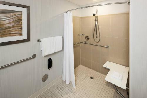 a bathroom with a shower with a shower curtain at Courtyard by Marriott Miami at Dolphin Mall in Miami