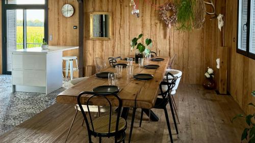 Cette chambre comprend une grande table en bois et une cuisine. dans l'établissement Chalet Pachamama - Pour 10 avec jacuzzi, à Fleury