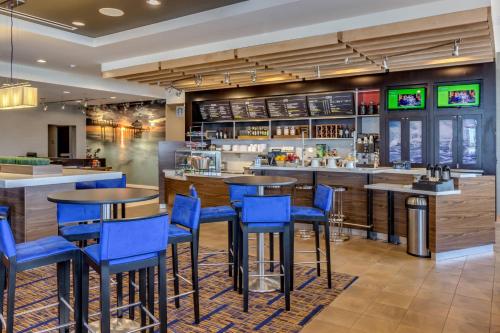 a restaurant with blue chairs and a bar at Courtyard by Marriott St. Petersburg Clearwater/Madeira Beach in St Pete Beach