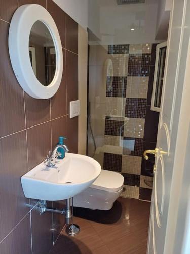 a bathroom with a sink and a toilet and a mirror at RMG Home in Fisciano