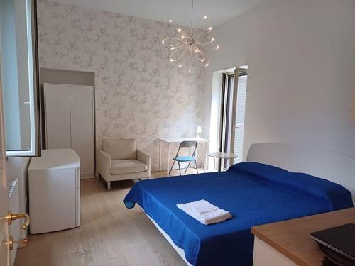 a bedroom with a blue bed and a chair at RMG Home in Fisciano