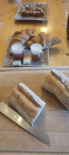 une table avec deux assiettes de pain et un couteau dans l'établissement La Bastide, Chambre d'hôtes, à Castagniers