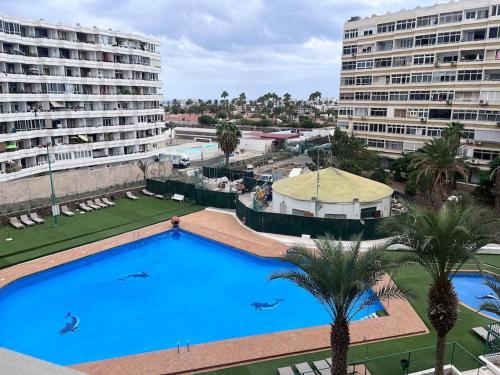 ein großer Pool vor zwei großen Gebäuden in der Unterkunft Design seaview flat next to Yumbo in Playa del Ingles