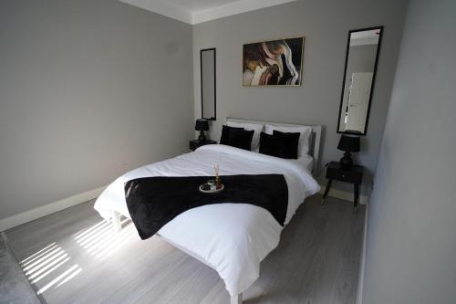 a bedroom with a bed with a black and white blanket at City Chic Retreat In Birmingham in Birmingham