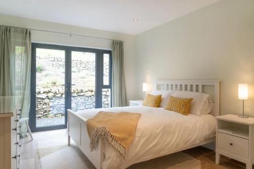 a bedroom with a large bed and a balcony at Secluded Luxury Off-Grid Hideaway with Apartment in Selkirk