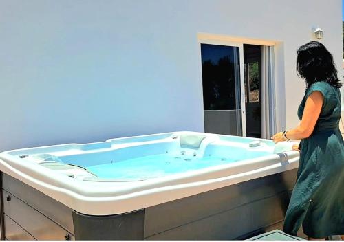 a woman standing in front of a hot tub at Apartamento Onix Jacuzzi in Tarajalejo