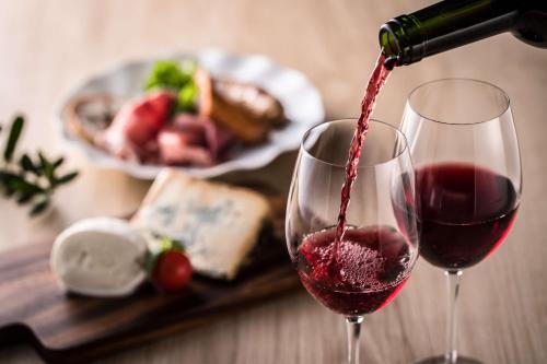 a person pouring red wine into a wine glass at Hilton Houston Plaza/Medical Center in Houston