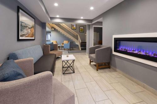 a living room with a fireplace and a tv at La Quinta Inn by Wyndham Sheboygan in Sheboygan