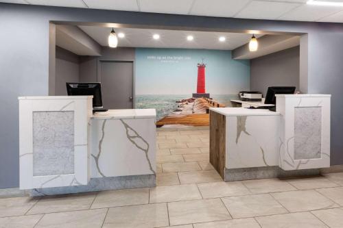 a waiting room with a red lighthouse on the wall at La Quinta Inn by Wyndham Sheboygan in Sheboygan