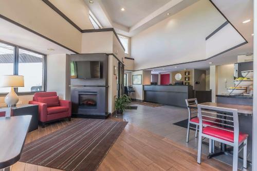 a living room with a red chair and a fireplace at Comfort Inn Cobourg in Cobourg