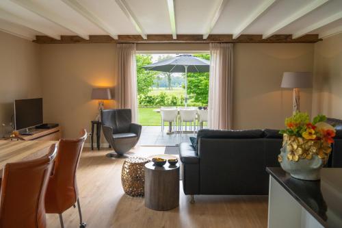 a living room with a couch and an umbrella at Familiehuis Het Gouden Plekje in Heeten