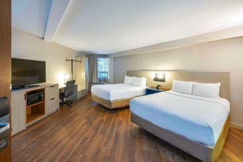 a hotel room with two beds and a flat screen tv at Comfort Inn Magnetic Hill in Moncton