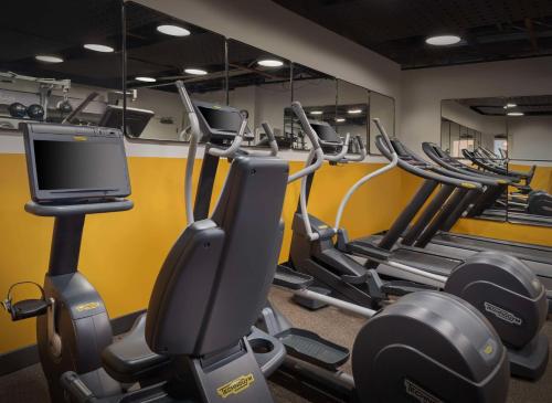 a gym with rows of tread machines and a tv at Freepoint Hotel Cambridge, Tapestry Collection by Hilton in Cambridge
