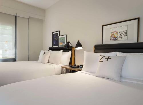 two beds in a hotel room with white pillows at Freepoint Hotel Cambridge, Tapestry Collection by Hilton in Cambridge