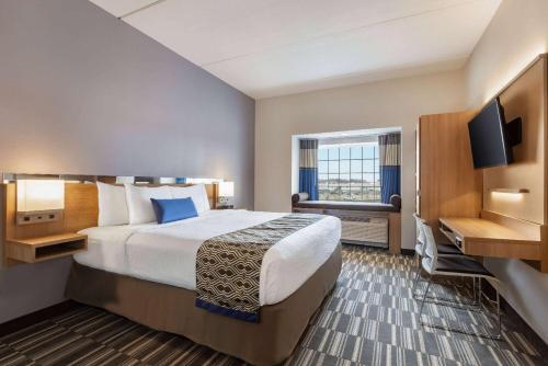 a hotel room with a large bed and a window at Microtel Inn & Suites by Wyndham Gambrills in Odenton