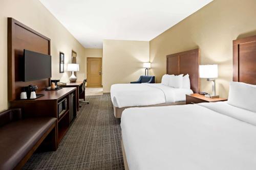 a hotel room with two beds and a flat screen tv at Comfort Inn & Suites High Point - Archdale in Archdale