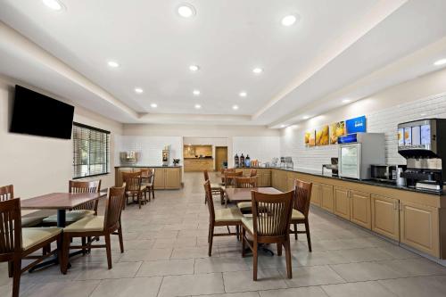 a restaurant with tables and chairs and a kitchen at Comfort Inn & Suites High Point - Archdale in Archdale