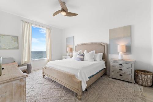 a white bedroom with a bed and a large window at Spanish Key 603 in Perdido Key