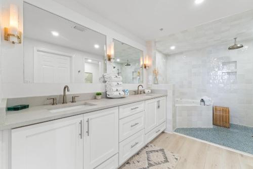 a white bathroom with two sinks and a tub at Spanish Key 603 in Perdido Key