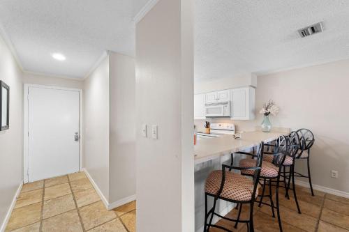 a kitchen with a counter and chairs in a room at Needle Rush Point F12 in Perdido Key