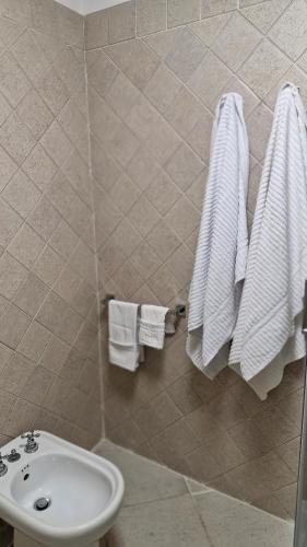 a bathroom with a sink and a toilet and towels at HOUSE MAGIE 2 e 3 in Marco Simone