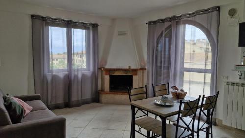 a living room with a table and a fireplace at HOUSE MAGIE 2 e 3 in Marco Simone