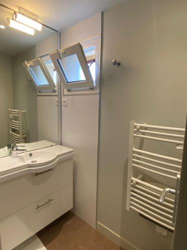 une salle de bain avec un lavabo et un miroir dans l'établissement VVF Fouesnant les Glénan, à Fouesnant