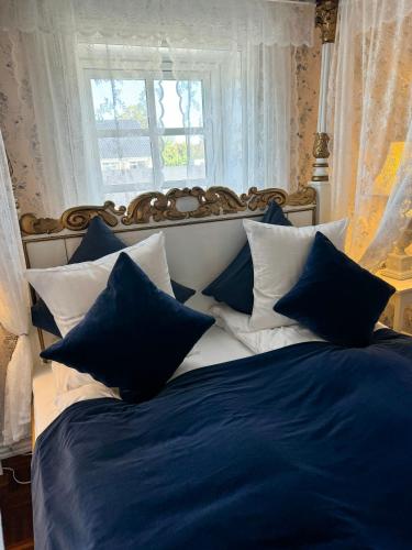 a bed with blue and white pillows and a window at Rold Gl Kro in Arden