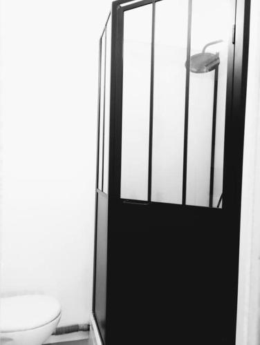 La salle de bains est pourvue d'une porte noire et de toilettes. dans l'établissement Le Studio De Gustave, à Lens