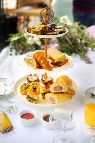 a three tiered plate of food on a table at The Palomar By Crossway in Chennai